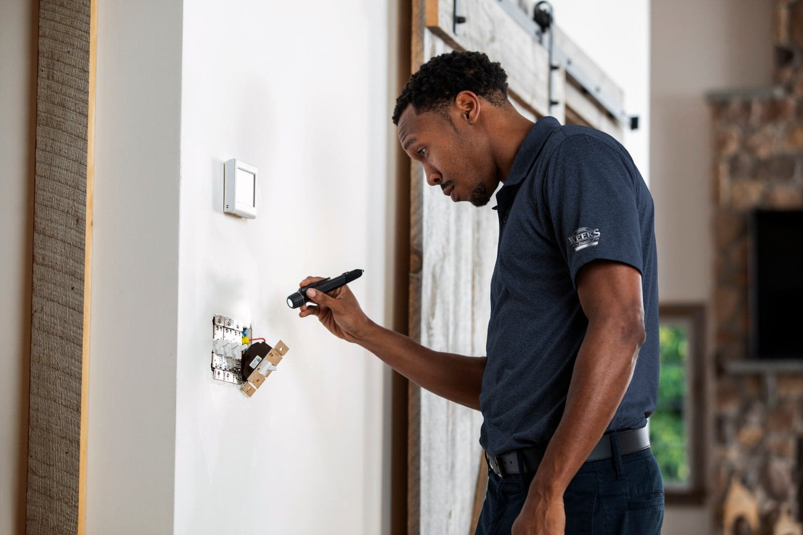 A Weeks electrician testing a wall outlet