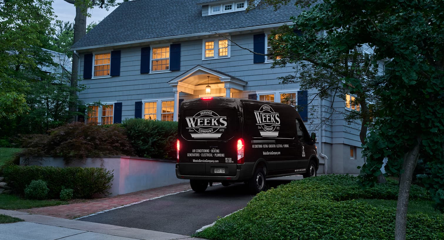 A Weeks Service Company service van parked in a residential driveway at dusk, arriving to provide 24/7 emergency AC repair services.