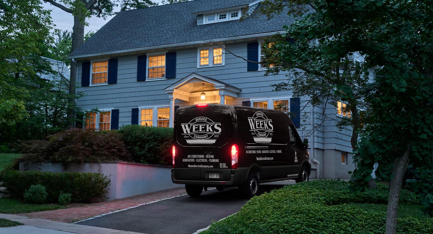 A Weeks Service Company service van parked in a residential driveway at night, arriving to provide 24/7 emergency heating repair services.