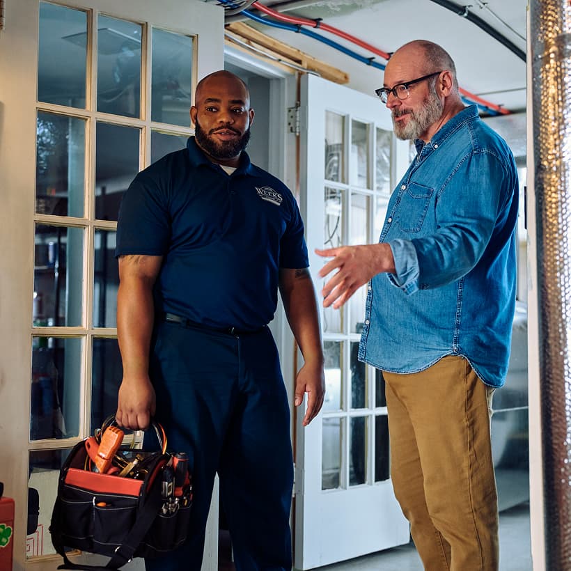 A Weeks technician discusses the repair and installation services with a homeowner.