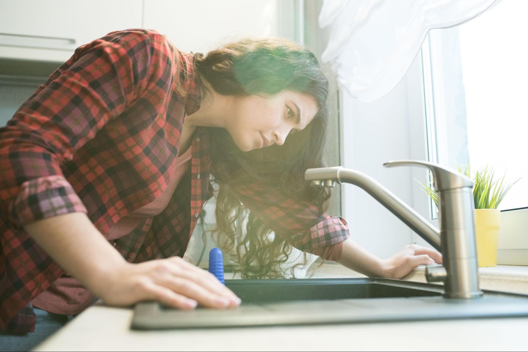 woman experiencing low water pressure at kitchen sink